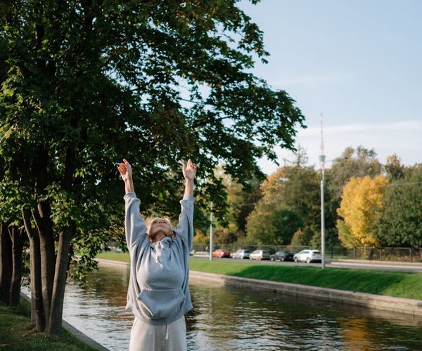 A person stretching their arms upwards, full of energy.
