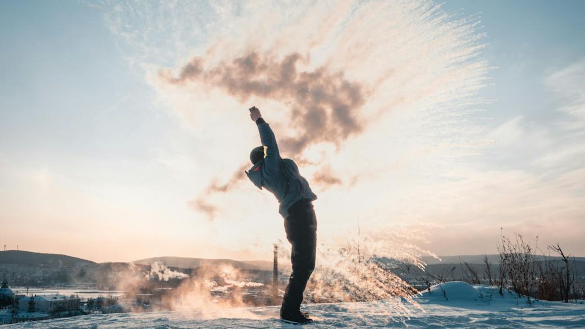 Silhouette of a person in a dynamic motion pose at sunrise.